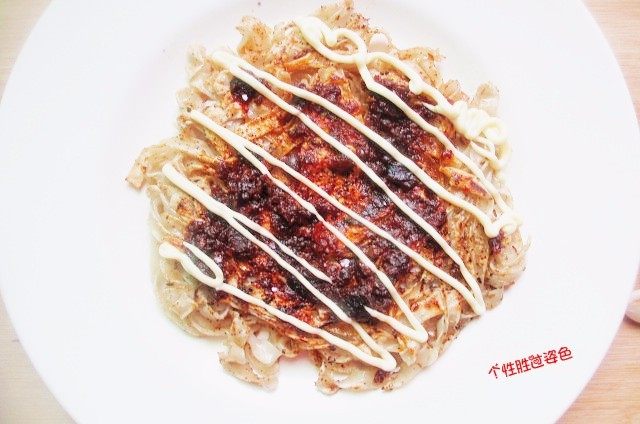 面条鸡蛋饼,煎好的面条饼放入盘中,抹上一层香辣牛肉酱,再挤上一点沙拉酱