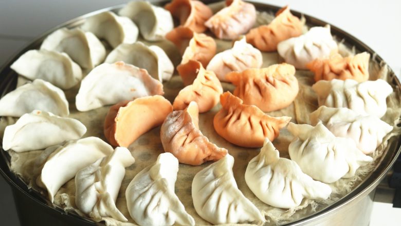 胡萝卜虾饺,蒸锅放篦子,下面垫纱布,把饺子全部片排在纱布上面。