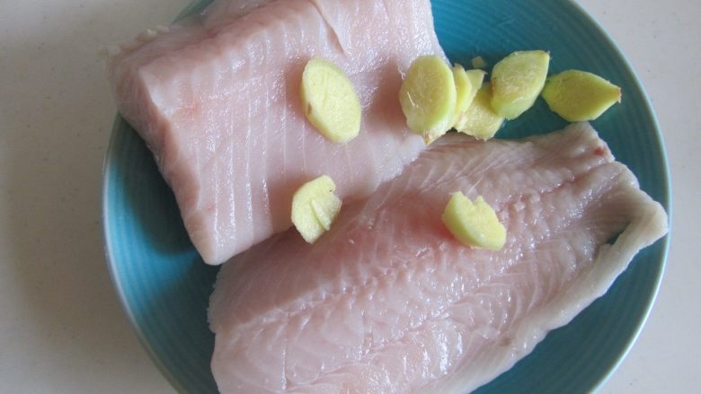丝瓜鱼丸汤,选取鱼腹两块肉,再加入少许姜片;