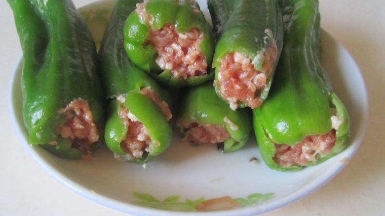 青椒酿肉,用筷子将调制好的<a style='color:red;display:inline-block;' href='/shicai/ 5353'>肉馅</a>塞入青椒中;