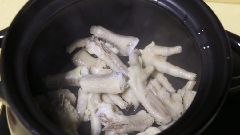 红枣花生凤爪汤,取一汤锅,将焯水的鸡爪放入锅中