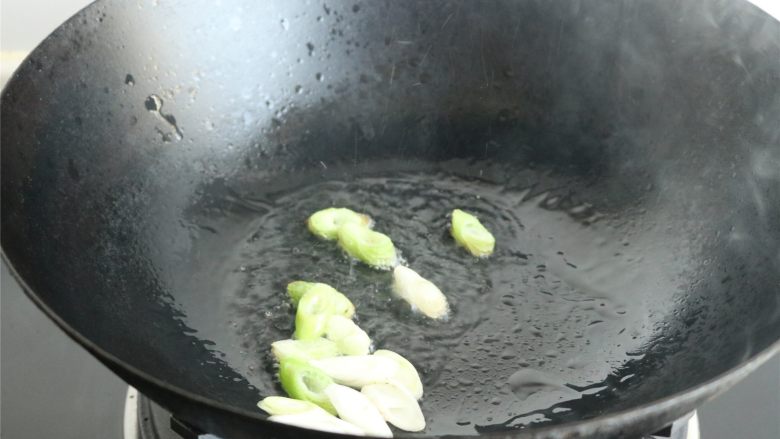 辣炒蛤,油温升高,能看到微微沸的样子,下入葱末爆香。