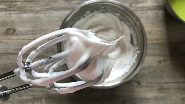 樱花草莓慕斯,蛋白加入适量柠檬汁分三次打入细砂糖30克,打至打蛋器提起呈尖尖的小弯角。
