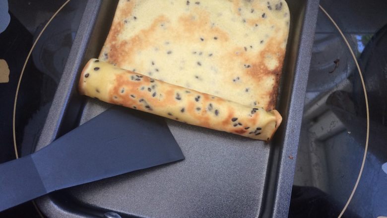 全麦黑芝麻蛋卷,小火煎制一面金黄,再翻面煎制金黄即可,用铲子在锅内顺势卷起