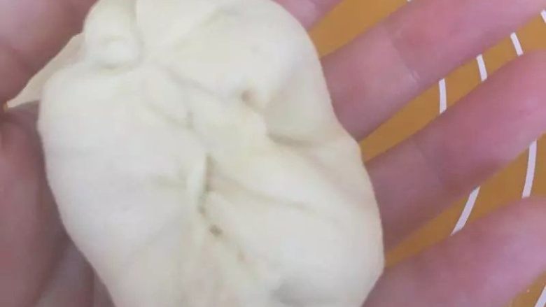 菠萝餐包【菠萝馅制作小窍门】,收口捏紧,搓成圆条型,收口向下。