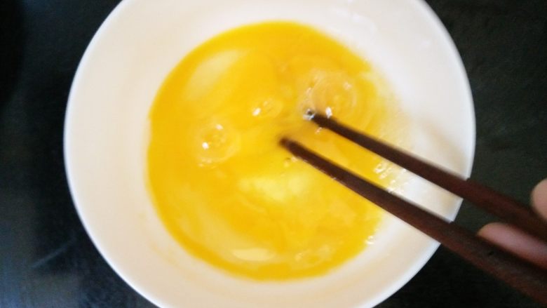 杂蔬火腿香菇饭,4.两颗鸡蛋打散,炒锅加入适量的油倒入鸡蛋炒好出锅备用