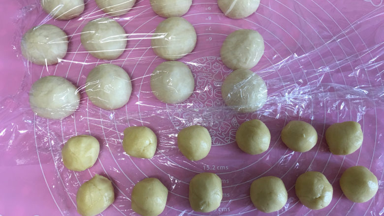 菠萝小面包,取出面团进行排气,将面团平均分成12份滚圆后醒面10分钟,醒面时间,把菠萝皮从冰箱中取出也分成12份并滚圆。
