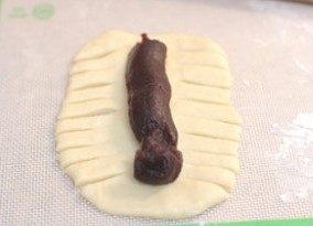 豆沙面包条(卡仕达酱),然后将豆沙挤在中间,两边的面团入图均匀滴分成10等分(先把上下切开,然后中间均匀滴分成8等份)
