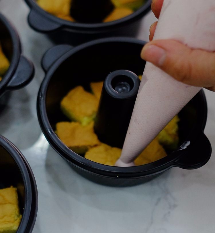火锅慕斯,在铺好一层蛋糕胚的模具里挤上一层草莓慕斯，然后再放一层蛋糕胚，再挤上一层慕斯，挤完后放冰箱冷藏30分钟左右