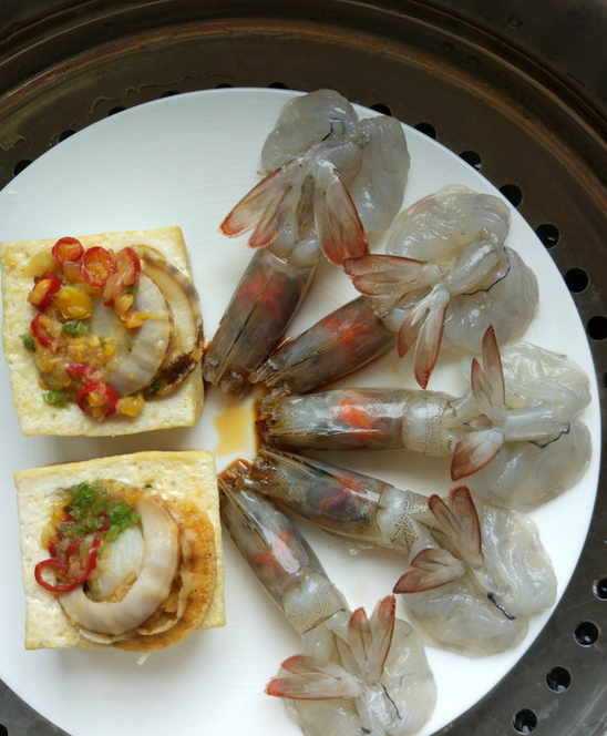 扇贝蝴蝶虾蒸豆腐(含豆腐做法),将调好的蒜蓉汁倒一些进豆腐里,扇贝放在上面,剩余的蒜蓉汁浇上,洒少许葱花儿和<a style='color:red;display:inline-block;' href='/shicai/ 86663'>红辣椒</a>圈