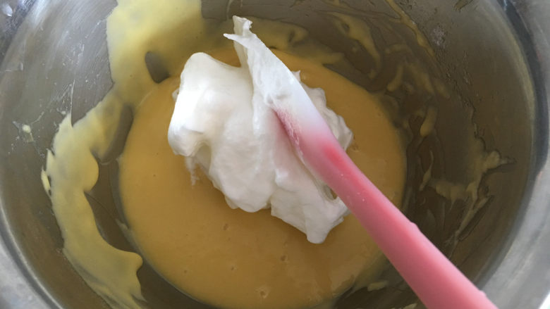 斑马纹戚风蛋糕,将打发好的蛋白一分为二,分成两份,(一份放入未加红曲粉的蛋黄糊中,一份放入加了红曲粉的蛋黄糊中)先取少量蛋白霜加入没加红曲粉的蛋黄糊中。