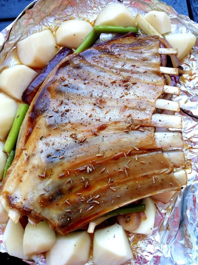 土豆烤羊排,将羊排和土豆、洋葱摆好,放入烤箱中上层,将腌肉的酱汁刷在羊排两面,另洒少许孜然和黑胡椒碎