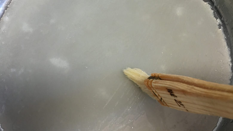 自制凉皮(洗面版),第一个凉皮降温的时候可以用准备的第二个啰啰做第二个凉皮,将第二个晾皮放入开水盆中蒸,盖上盖子。这时我们来取正在降温凉皮,凉皮表面刷油。