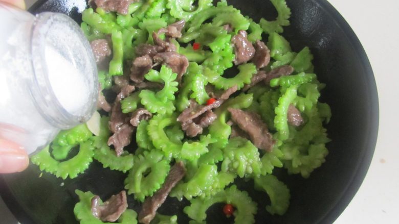 苦瓜炒牛肉, 再翻炒几下后加入适量的盐调味, 翻炒均匀即可。