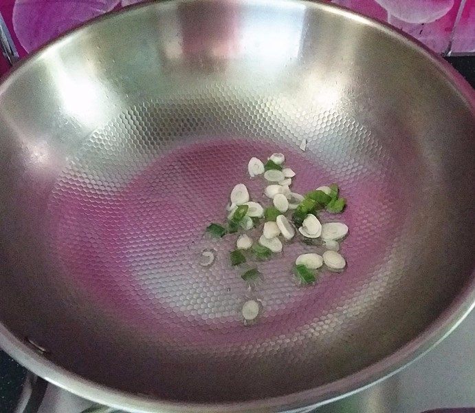 新蒜头炒苦瓜,炒锅加热重新倒油,爆香葱叶和蒜片