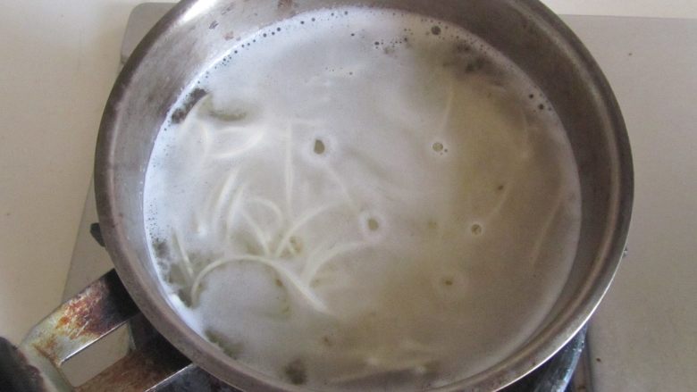 苋菜咸蛋面,面条煮开后加入少许水继续煮;