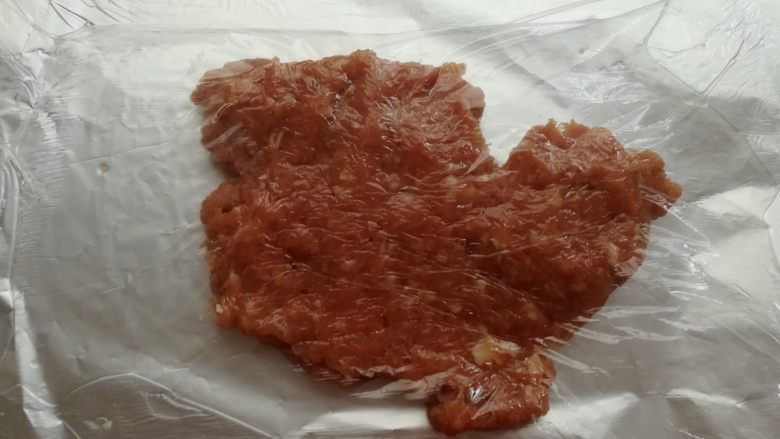 自制猪肉脯,取一张40cm长度的锡纸,在锡纸上抹一层油,放上一半的肉沫,盖一层保鲜膜