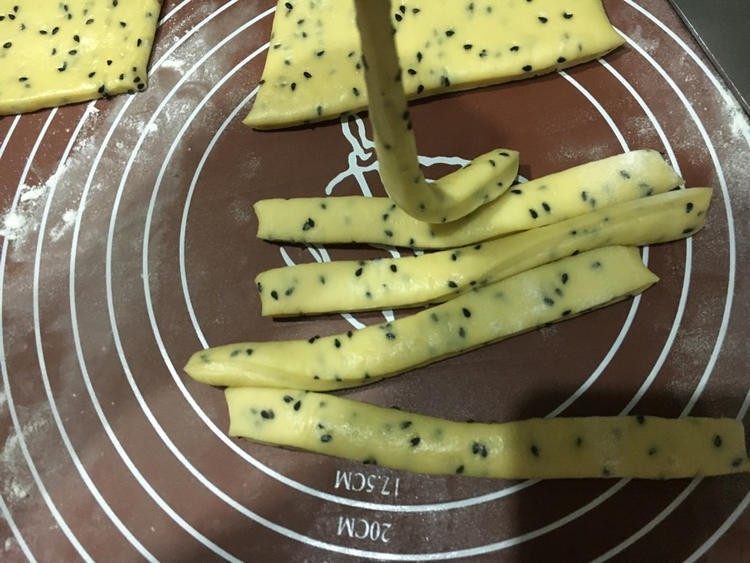 胖嘟嘟的面包棒,擀成需要的宽度,切成长条状对折卷起。「我差不多一厘米卷,6-8厘米长」