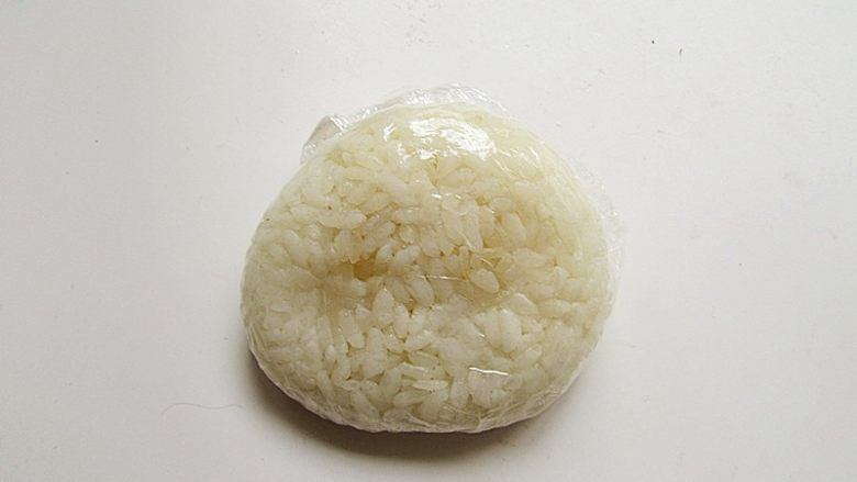 章鱼和宝宝出游记,饭团用保鲜膜包起来,团好再按扁,做成章鱼妈妈的头部