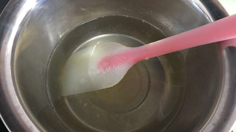 芒果水晶果冻,一边加热一边搅拌,搅拌至糖完全溶解后关火,趁水热的时候倒入溶解好的吉利丁溶液。