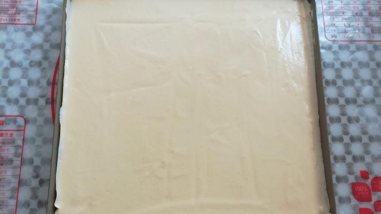 草莓蛋糕盒子,蛋糕糊倒入铺了油纸的烤盘里,依靠面糊的流动性流向四周,高出的蛋糕糊用刮板刮平一点,有大气泡的地方用牙签划一下
