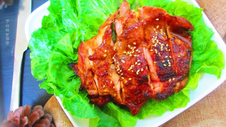 碳烤鸡腿肉,把生菜扑在盘子里,放上烤好的鸡腿,用刀切开,撒上白芝麻即可开吃