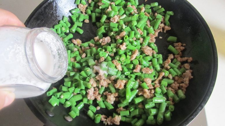 肉末橄榄菜炒豆角,翻炒几下后加入适量的盐翻炒均匀;