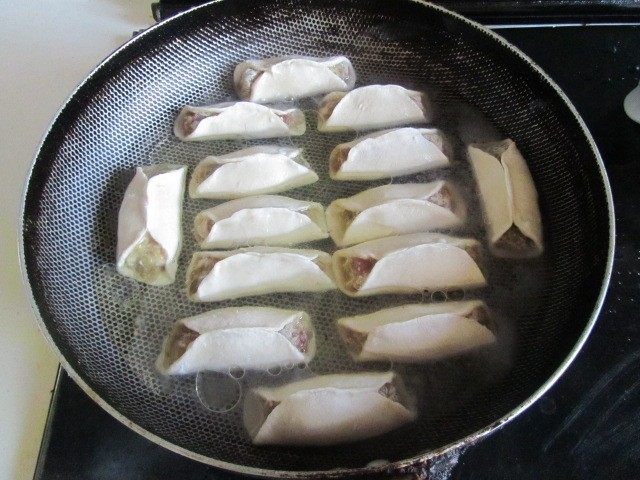 西葫芦肉馅锅贴,烧热锅, 将锅贴摆放好, 再加入适量的水和油;