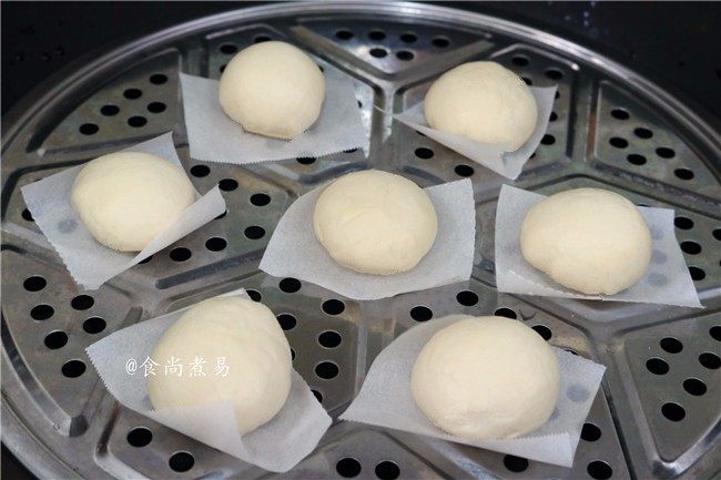 绵密香甜的流沙包,包子垫上防黏油纸,码放于蒸笼上,静置15分钟后打开火,大火蒸10分钟