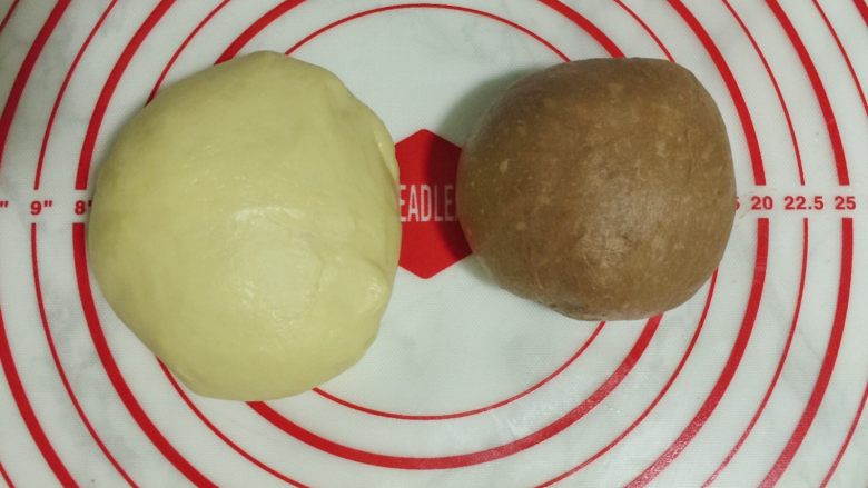 双色麻花吐司,分割成一大一小2个面团,小面团加可可粉揉匀。(用手沾温水揉更容易揉均匀)盖保鲜膜,发酵至2.5倍左右。