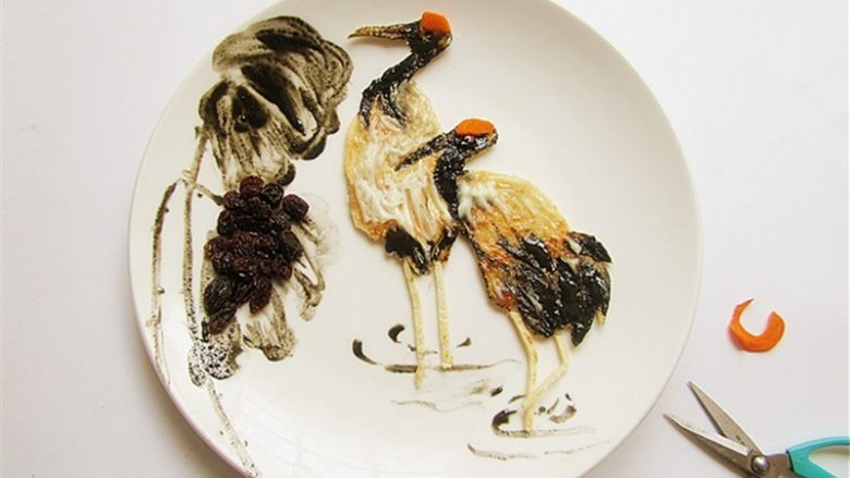 国画风趣味餐,荷叶黑色部分用<a style='color:red;display:inline-block;' href='/shicai/ 603'>葡萄干</a>摆放,鹤的红掌用胡萝卜或樱桃皮摆上,并画出水的波纹