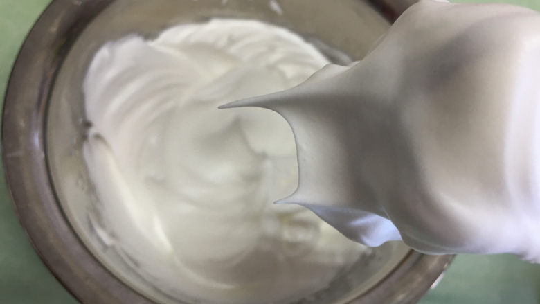手指饼干,蛋白分次加入30克细砂糖进行打发,打发至蛋白提起有挺而有力的尖角。