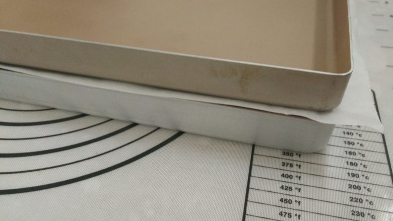 日式红豆饼,11.面团上盖油纸,油纸上再盖上一个平烤盘,进行二次发酵,烤箱内放一碗热水保持面团湿度