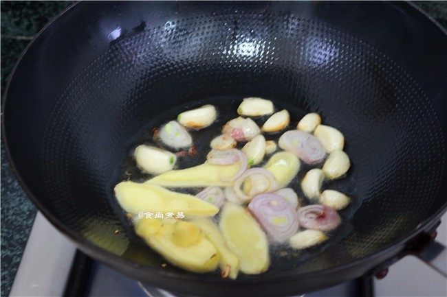 红烧牛蹄,热锅倒油,下蒜瓣、姜片、葱片爆香
