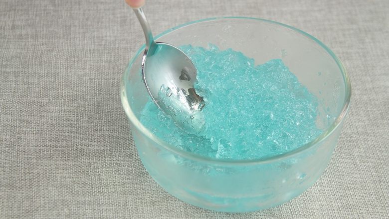 天空鸡尾酒果冻,将牛奶和鸡尾酒都放进冰箱冷藏3小时凝结成果冻状,取出用勺子压碎。