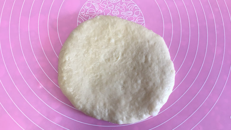 面包机版黄桃面包派,1面团醒发完毕,取较大一块面团,擀成模具底大小的圆。
