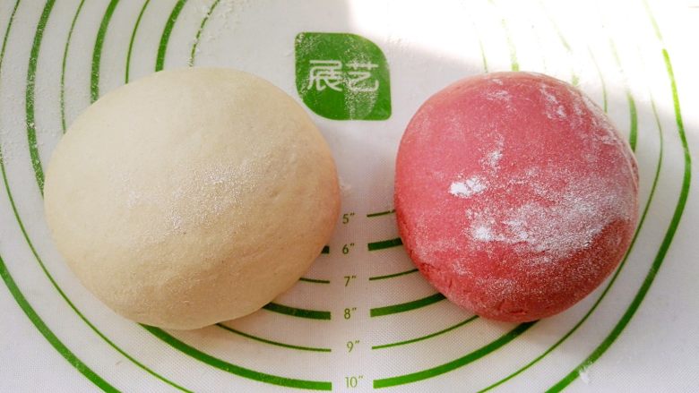 百变面食之双色小猪馒头, 放揉面垫或案板上开始用拳头捣, 用掌跟揉、折叠,并重复此动作对面团进行排气,直到把面团揉光滑(分次撒少许干粉防粘)。