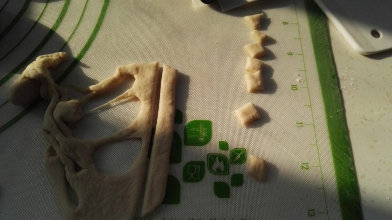 百变面食之双色小猪馒头,剩下的面片切分出猪耳朵(随便弄就可以,成品不会丑),面片背面用筷子抹水逐个粘猪头上当耳朵。