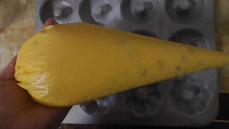 百香果小蛋糕,翻拌好的面糊倒入到裱花袋里，冬天放在室内静置15分钟左右即可。夏天的话送入冰箱冷藏室静置15分钟左右