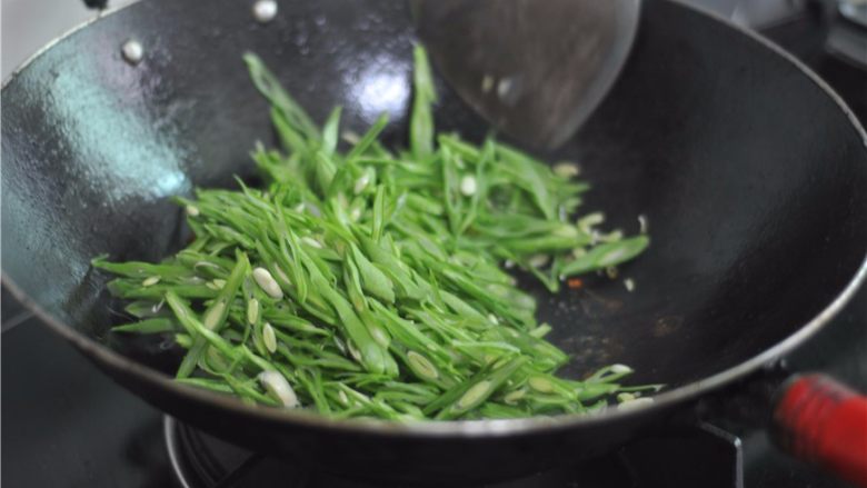 四季豆炒肉肠,稍微烧制片刻，撒入少许盐，翻炒均匀