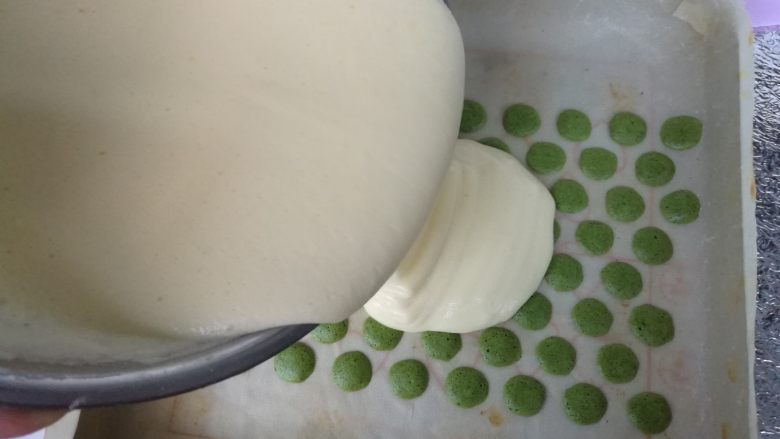抹茶波点蛋糕卷,在烘烤好的波点上面倒入蛋糊,刮刀抹平。