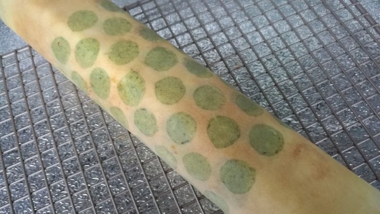 抹茶波点蛋糕卷,借助油纸卷成卷,送入冰箱冷藏定型。