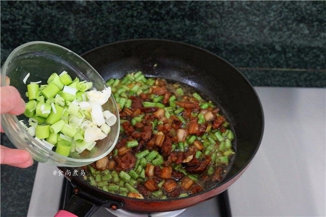 五花肉蒜香腊味焖饭,倒入蒜苗翻炒均匀