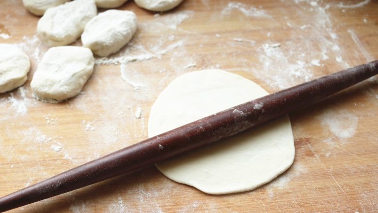 土豆丝卷饼,取一个面剂子,按平,用擀面杖擀大一点。