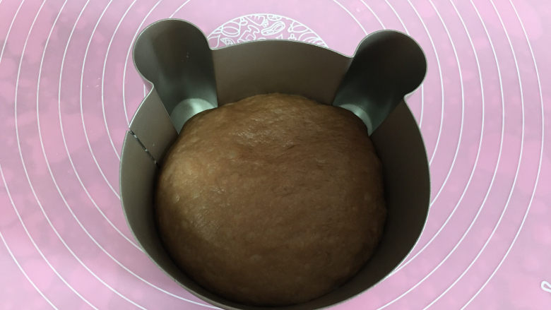 可可味小熊面包,放入小熊模具中,用手按压面团,把耳朵部位也压入一部分面团。