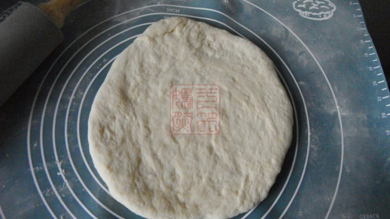 巧克力甜甜圈,将发酵好面团从面包机中取出,用擀面杖擀成圆片,