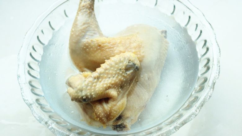 葱油白斩鸡,投入冰水,浸泡一会,中间换水一次。