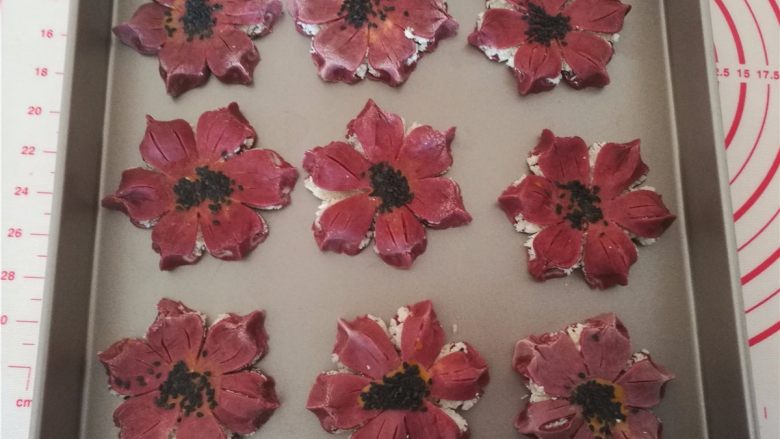 桃花酥,10.中间刷上蛋黄液,撒上黑芝麻,放入烤盘里