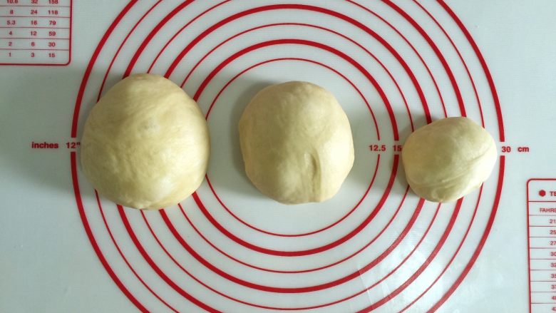 圣诞老人面包,面团取出排气,分割成150克、120克、剩下的面团。制作时除操作面团外,其余面团全程覆盖保鲜膜。