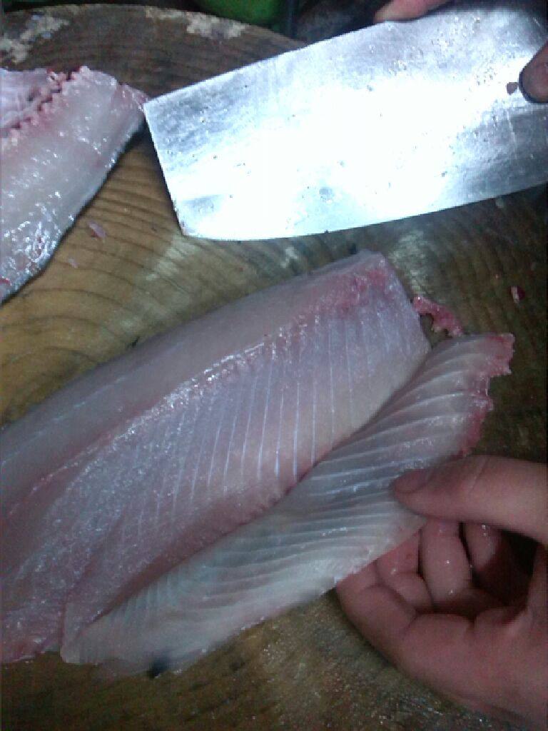 酸菜鱼,接着片鱼。这是最关键的地方。鱼肉不能太厚。但也不能过份薄,每片在两毫米左右是最理想的。片前先吧鱼背刮一下。防止鱼滑,一般我们是片蝴蝶刀。就是一刀下不片断。第二刀再片断。下刀角度在四十五度,一手轻按片鱼的位置。